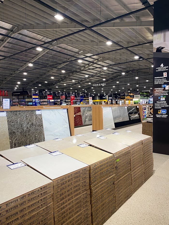 Spacious industrial warehouse with tiles and construction materials on display, suitable for home renovation.