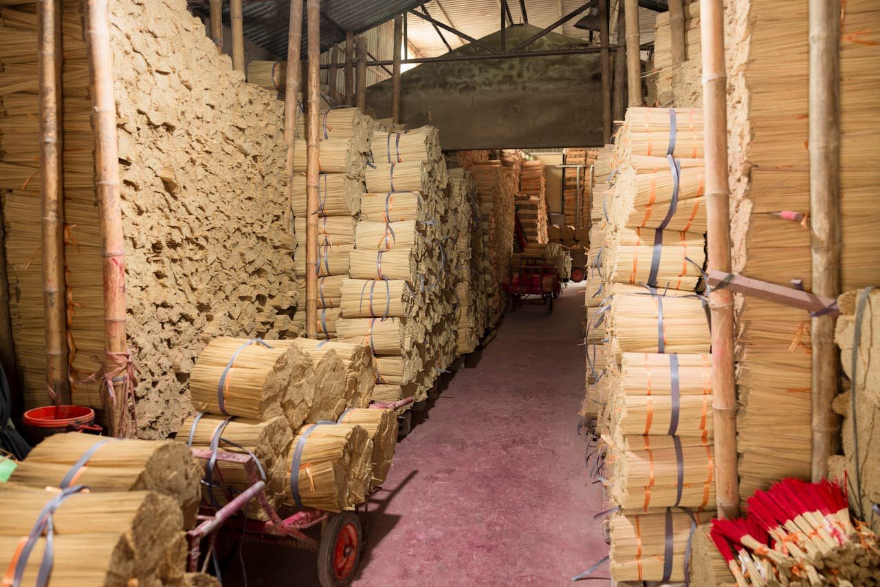 Stacks of incense sticks stored in an indoor warehouse, showcasing production environment.