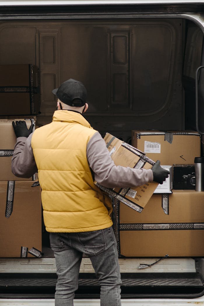 About Deliveryman organizing packages into a van for distribution.